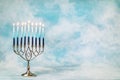 A silver menorah for the Jewish holiday Hanukkah with burning glowing eight candles