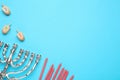 Silver menorah, red candles and Hanukkah dreidels with Nun, He, Gimel symbols on blue background, flat lay. Space for text Royalty Free Stock Photo