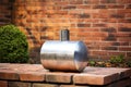 a silver metal cylinder of propane gas on a brick wall Royalty Free Stock Photo