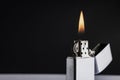 Silver metal lighter with flame on black background , classic lighter Royalty Free Stock Photo