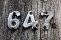 Metal numbers 647 nailed to a wooden pole