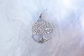 silver metal pendant in the shape of the tree