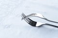 Silver stainless steel two interaction fork on white tablecloth food luxury dinner background