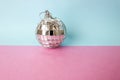 Silver mirror musical club disco ball xmas festive Christmas ball, Christmas toy plastered on glitter gray pink purple background Royalty Free Stock Photo