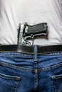 Silver 9mm handgun in waistband from behind