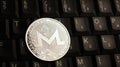 Silver Monero XMR coin on laptop keyboard Royalty Free Stock Photo