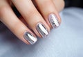 silver nail manicure with metallics in womens hands.