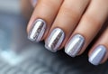 silver nail manicure with metallics in womens hands.