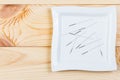 Silver needles for traditional Chinese acupuncture medicine lie on a square plate on a wooden table. Royalty Free Stock Photo