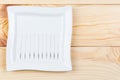 Silver needles for traditional Chinese acupuncture medicine lie on a square plate on a wooden table. Royalty Free Stock Photo