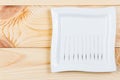 Silver needles for traditional Chinese acupuncture medicine lie on a square plate on a wooden table. Royalty Free Stock Photo