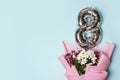 8 silver number ballon with bouquet of flowers. blue background