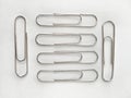 Silver paperclips arranged in a row as if in a row Royalty Free Stock Photo