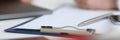 Silver pen lying on opened notebook sheet closeup Royalty Free Stock Photo