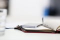 Silver pen lying on opened notebook sheet closeup