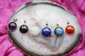 Silver pendants with various mineral stones on agate and pink textyle background