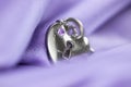 Silver pendent wrapped in violet satin fabric