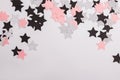 Silver, pink and black paper stars isolated on white background.