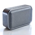 Silver rectangular portable Bluetooth speaker with perforated grille and buttons on white Royalty Free Stock Photo