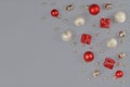 Silver and Red Christmas ornaments like small gift boxes, round baubles, bells and stars on gray background with copy space Royalty Free Stock Photo