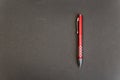 Silver-red pen against a black background. Ballpoint pen with a pattern of red squares Royalty Free Stock Photo