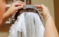 Silver and rhinestone hair accessory being placed by a woman`s hands in a bride`s hair as she dresses on her wedding day. Royalty Free Stock Photo