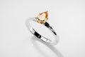 Silver Ring with Amber Pear Diamond Placed on Glossy Background 3D Rendering