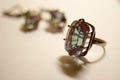 Silver ring and earrings with a big stone mystic topaz on a white table