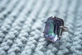 Silver ring with a large stone mystical topaz on a knitted gray table Royalty Free Stock Photo