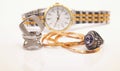 Silver rings of different shapes and a gold chain lie on the background of a women's wristwatch Royalty Free Stock Photo