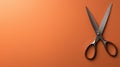 Silver scissors on orange background