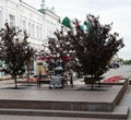 Silver sculpture of a beautiful young lady on a bench in the historical center of Omsk in summer