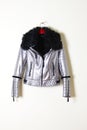 Silver sheepskin coat with black collar and zipper. Jacket on a hanger. Outerwear. Vertical.