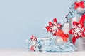 Silver shiny ball with red silk bow closeup and festive christmas decorations and gift boxes on soft light blue color background. Royalty Free Stock Photo