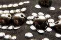 Silver shiny beads and sequins in vintage style are sewn on black coarse fabric Royalty Free Stock Photo