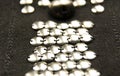 Silver shiny beads and sequins in vintage style are sewn on black coarse fabric Royalty Free Stock Photo