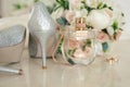 Silver shoes of the bride , perfume, bouquet and wedding rings on the dressing table near the mirror. Royalty Free Stock Photo