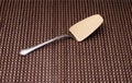 Silver shovel cake with golden spraying at the end on the mat. Royalty Free Stock Photo