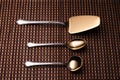 Silver shovel cake, teaspoon and spoon for sugar on the pattern table mat. Royalty Free Stock Photo