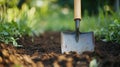 Silver shovel in garden soil surrounded by green foliage Royalty Free Stock Photo