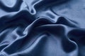 Silver silk background with a folds. Abstract texture of rippled silk surface