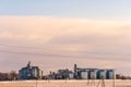 Silver silos against the blue sky in winter. Grain storage in winter at low temperatures. Production for processing, drying,