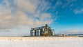 Silver silos against the blue sky in winter. Grain storage in winter at low temperatures. Production for processing, drying,