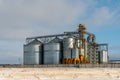 Silver silos against the blue sky in winter. Grain storage in winter at low temperatures. Production for processing, drying,