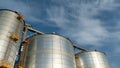 silver silos on agro manufacturing plant for processing drying cleaning and storage of agricultural products, flour, cereals and Royalty Free Stock Photo