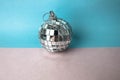 Silver snowy small round xmas festive Christmas ball, Christmas toy plastered over sparkles on a gray blue background Royalty Free Stock Photo