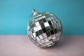 Silver snowy small round xmas festive Christmas ball, Christmas toy plastered over sparkles on a gray blue background Royalty Free Stock Photo