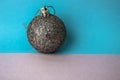 Silver snowy small round xmas festive Christmas ball, Christmas toy plastered over sparkles on a gray blue background Royalty Free Stock Photo