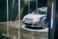 A silver, soapy car stands at a self-service car wash.Car wash self-service Royalty Free Stock Photo