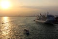 SILVER SPIRIT cruise ship moored, small excursion boat underway crossing the harbor at sunset in Venice, Italy